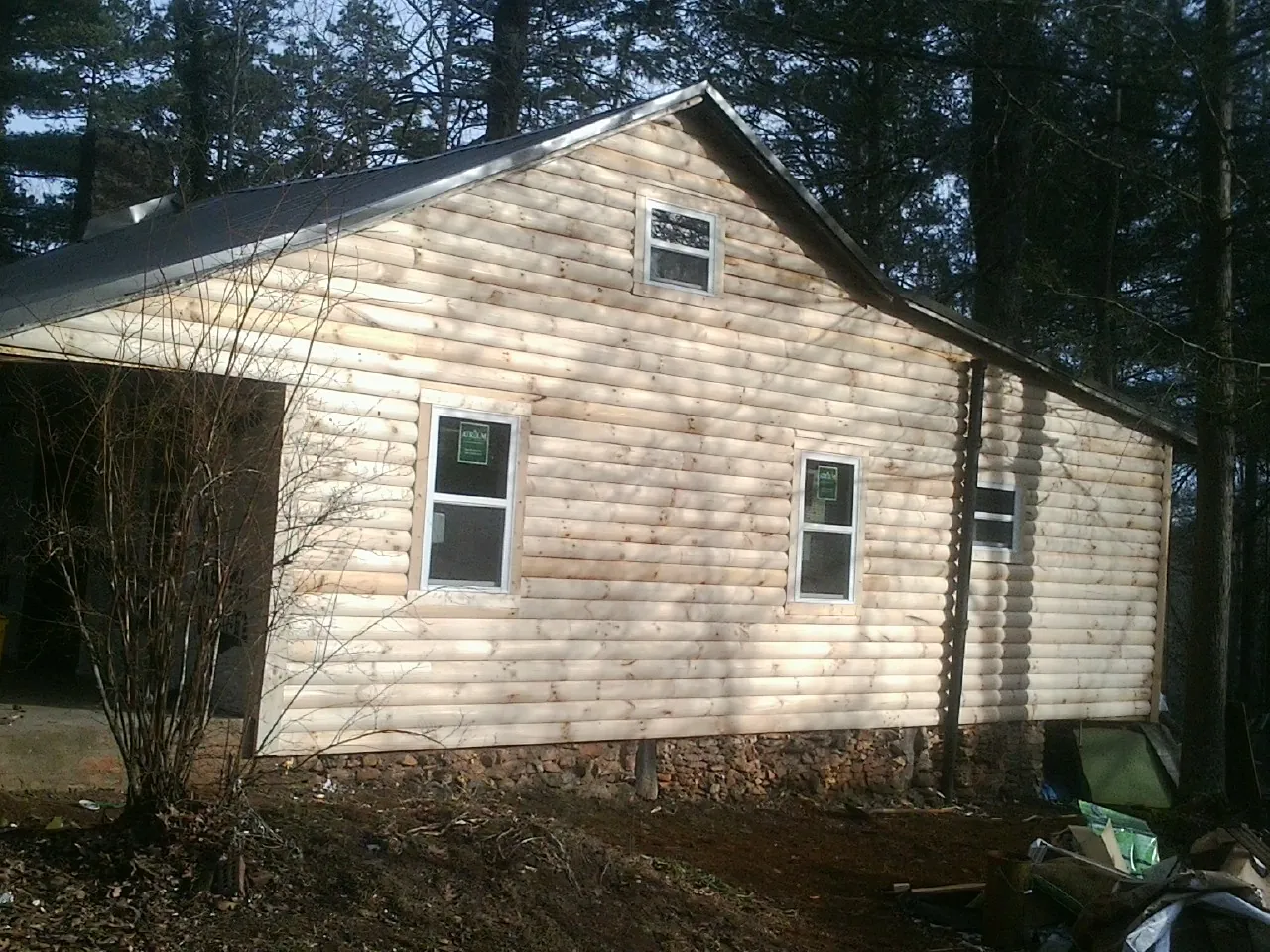 New log siding and dark metal roofing on a gable end in Mount Pleasant