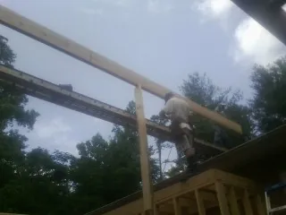 Carpenter setting a ridge beam over a new addition frame — Ice Dam Removal by Roofing Brothers in Mount Pleasant