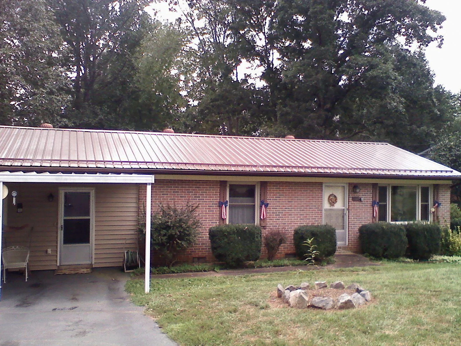 Bronze metal roof and carport on a brick ranch home — Roof Repair work by our crew in Mount Pleasant